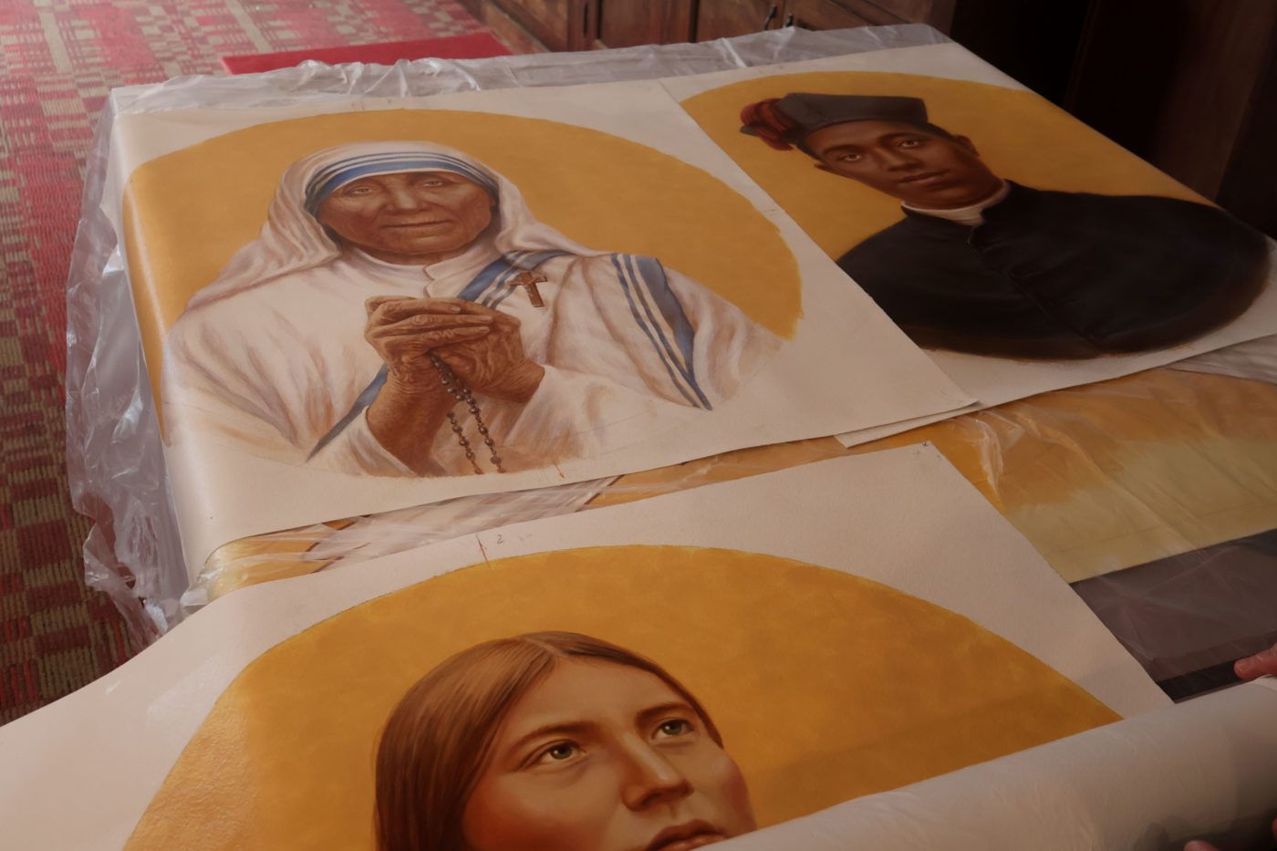 Three portraits lay on a table